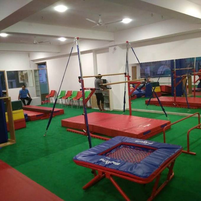 Bars, trampoline and coloured mats inside the Aerial Zone gym